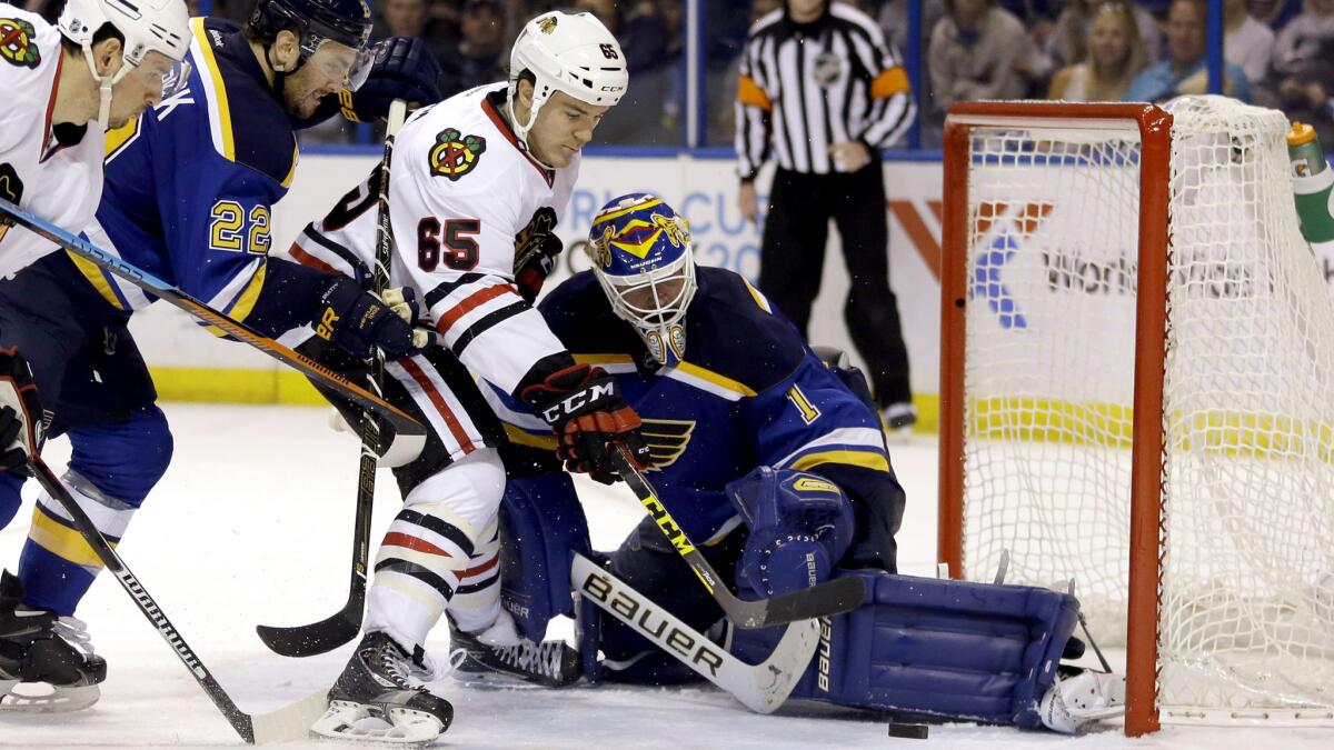 Blackhawks right wing Andrew Shaw (65) scores past Blues goalie Brian Elliott, right, during the third period Friday.