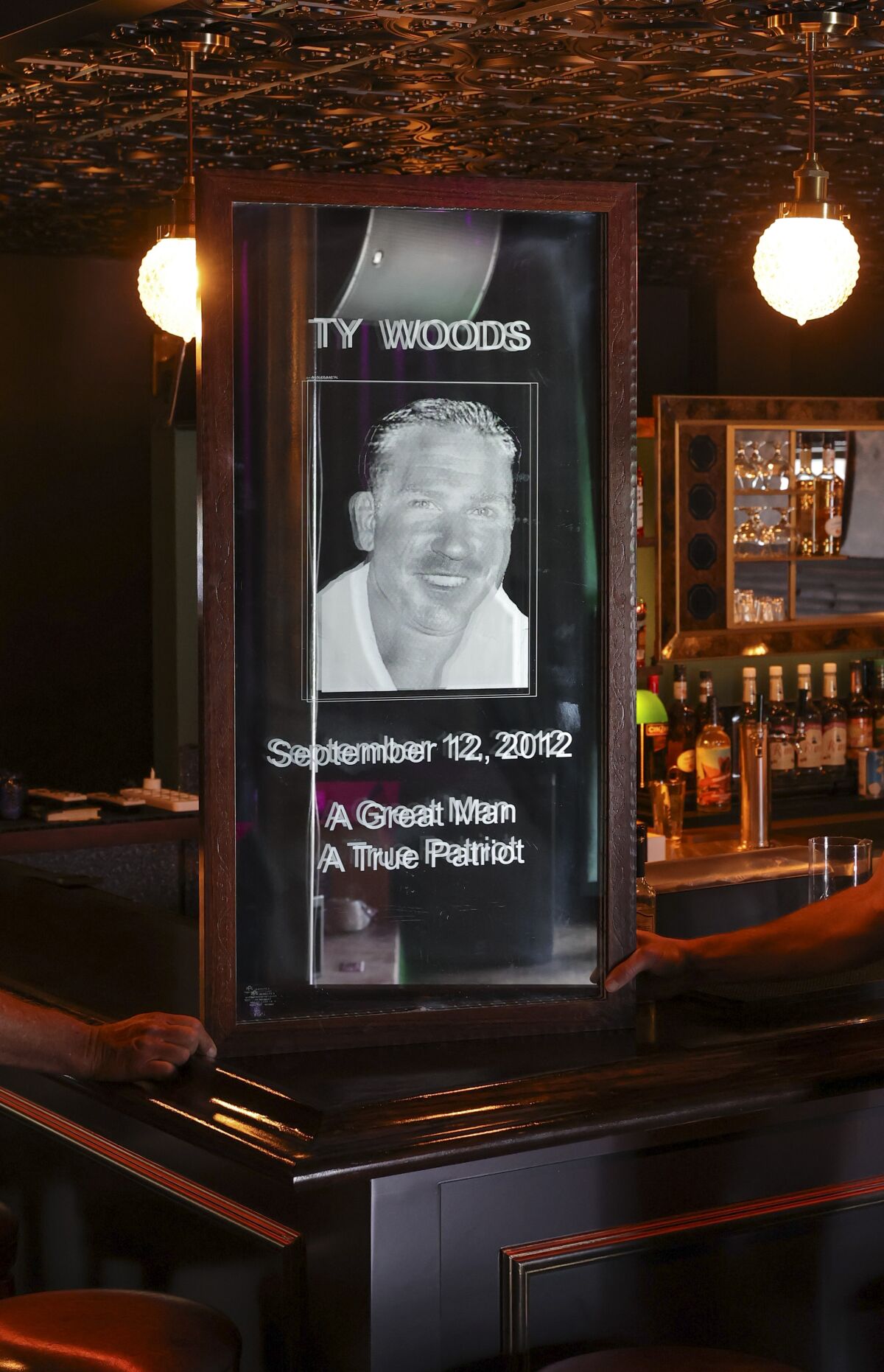 A mirror engraved with a picture of fallen Navy Seal Ty Woods at the Salty Frog.