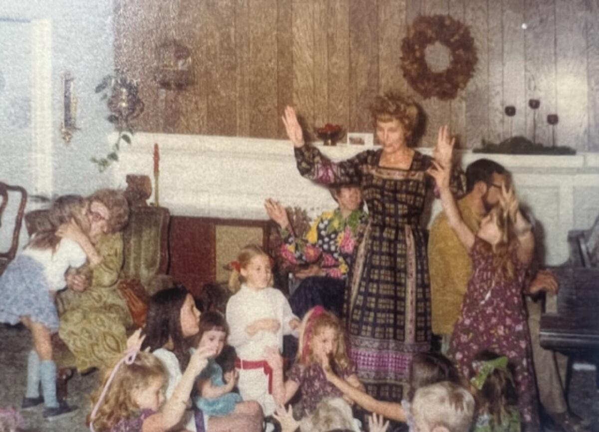 Martha O'Meara, standing, leads Christmas singing during the early years of the party circa 1975.