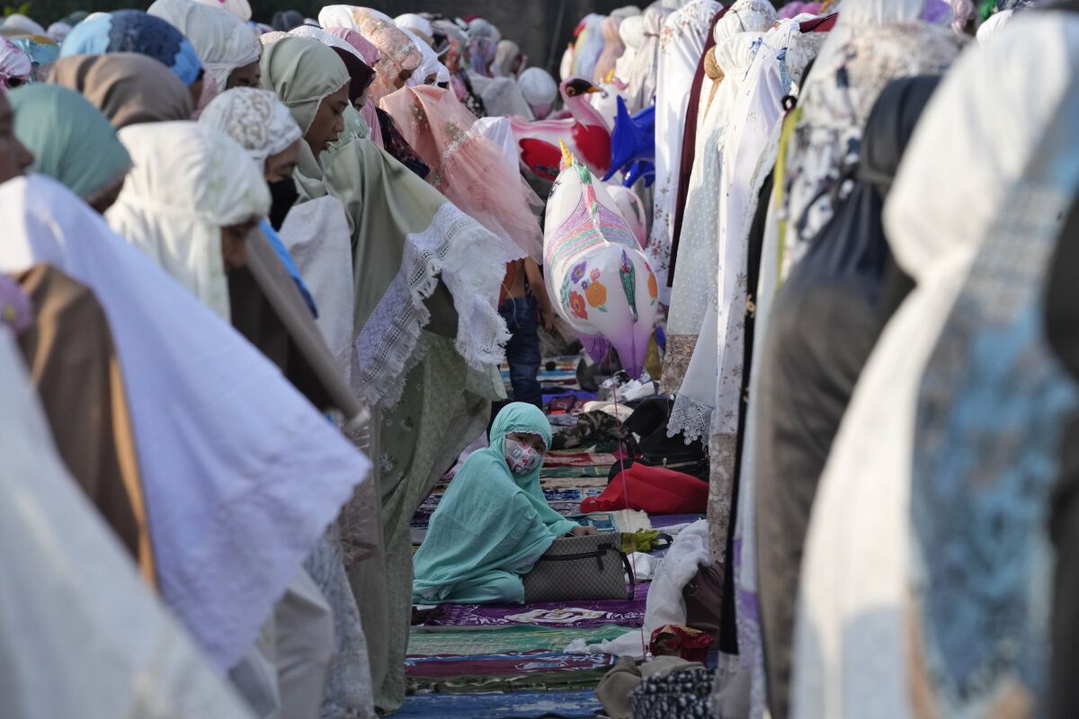 Muslim women offer Eid al-Fitr prayers to mark the end of the holy fasting month of Ramadan at Sunda Kelapa port in Jakarta, Indonesia, Monday, May 2, 2022. (AP Photo/Tatan Syuflana)
