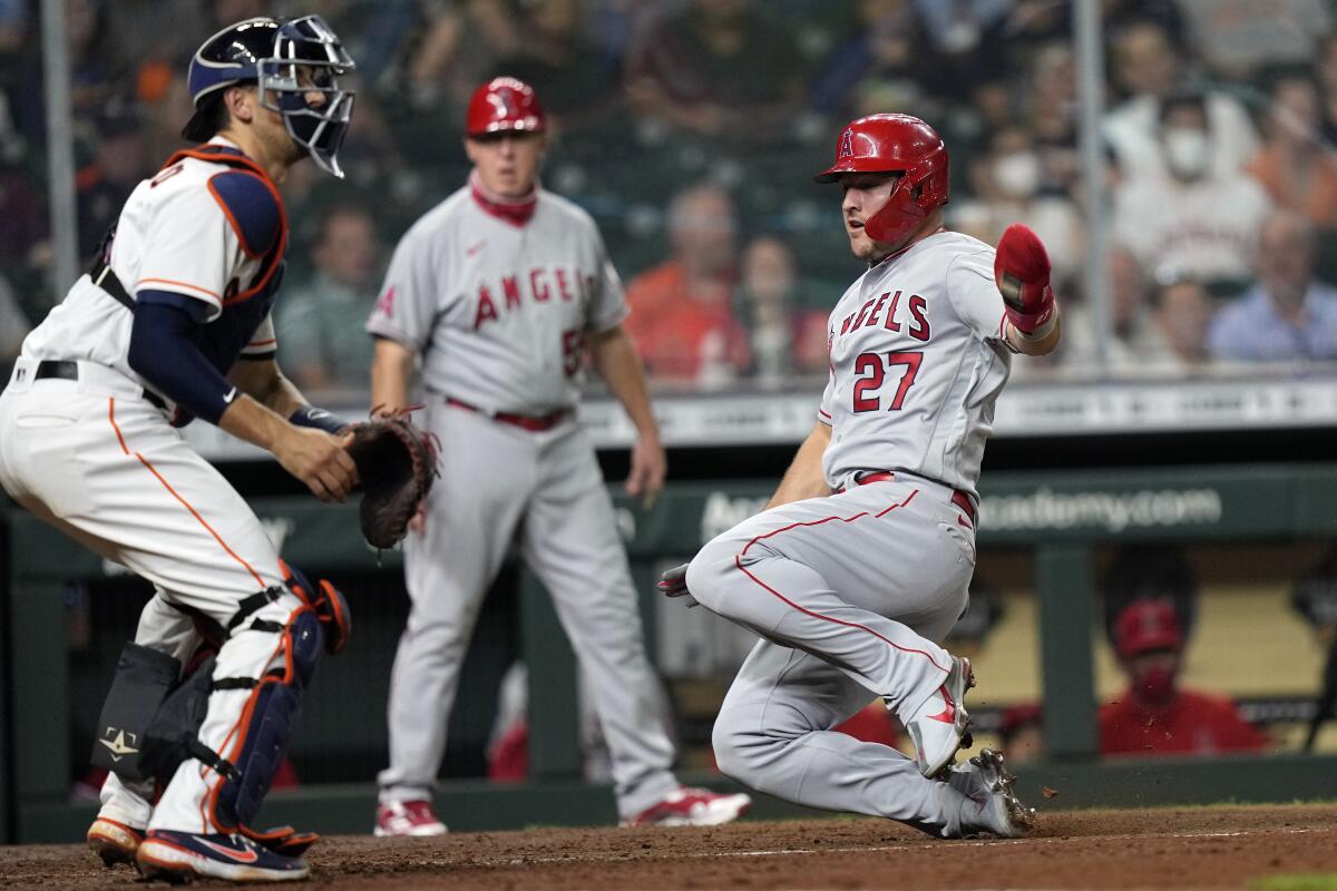 The Angels' Mike Trout scores as Houston Astros catcher Jason Castro waits for the throw.