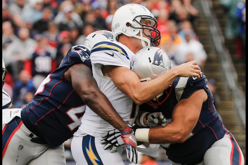 The Patriots' David Harris and Lawrence Guy wrap up Chargers quarterback Philip Rivers in the fourth quarter.