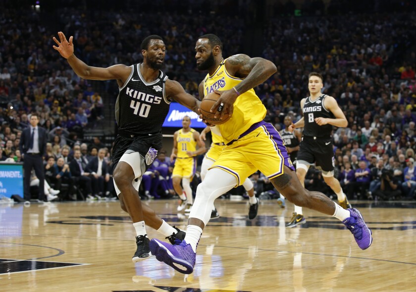 The Lakers' LeBron James drives on the Kings' Harrison Barnes. The Lakers had 81 first-half points, matching a key number from Kobe Bryant's career.