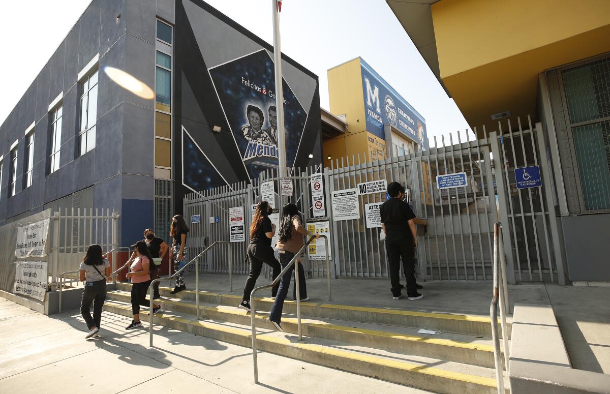 Students walk up steps to school gates