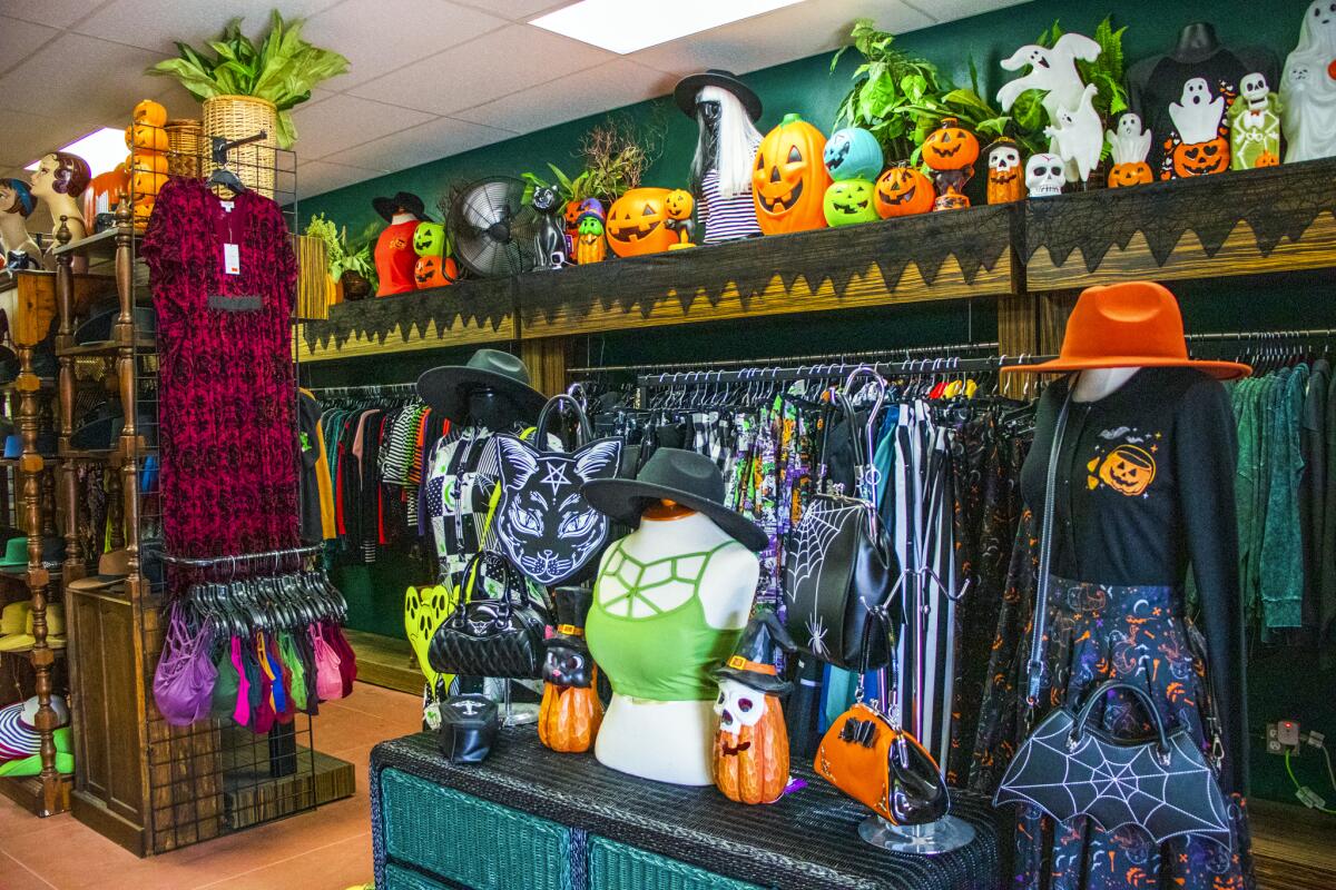 Halloween items at Bewitched Wicker include slothing and shelves lined with pumpkins and Jack o'Lanterns