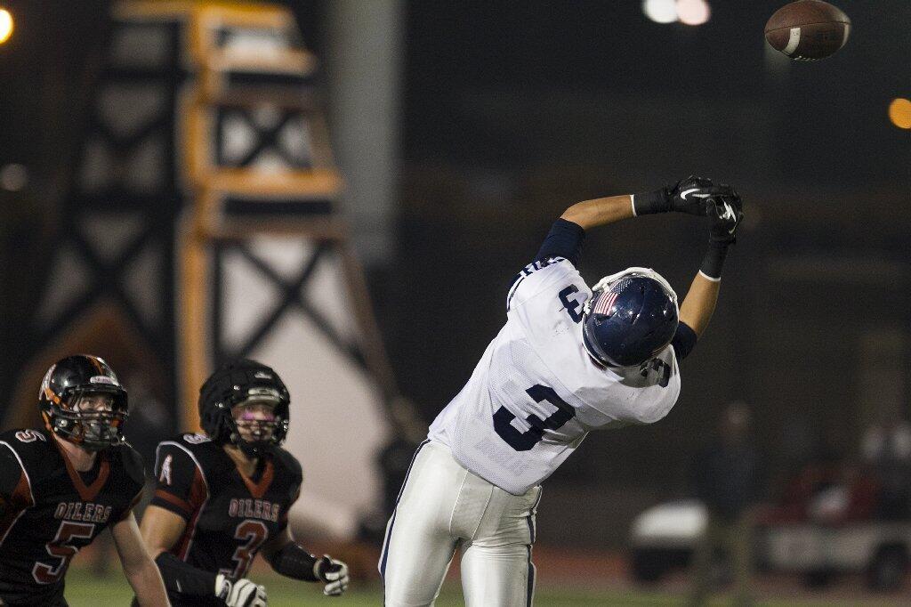 Newport Harbor's Keaton Cablay tips a ball up that was intercepted in the fourth quarter during a game against Huntington Beach on Friday.
