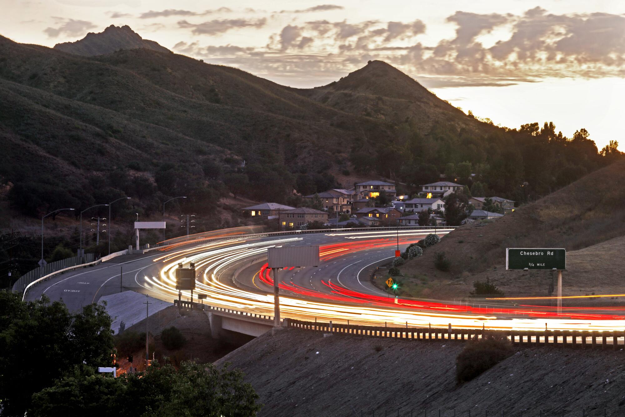 An aerial view captures ribbons of headlights and taillights on the 101 Freeway in Agoura Hills