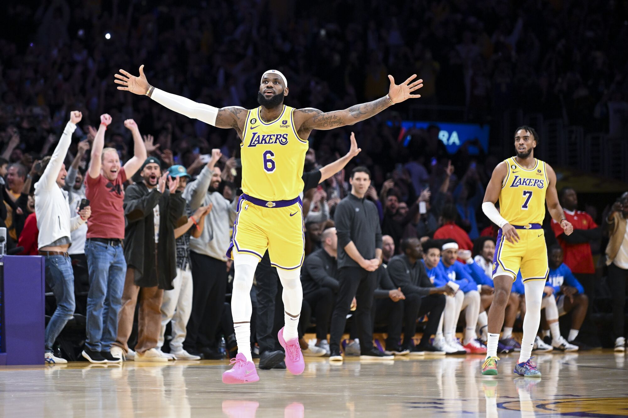 LeBron James and fans standing courtside celebrate after he made the shot to become the NBA's all-time scoring leader.