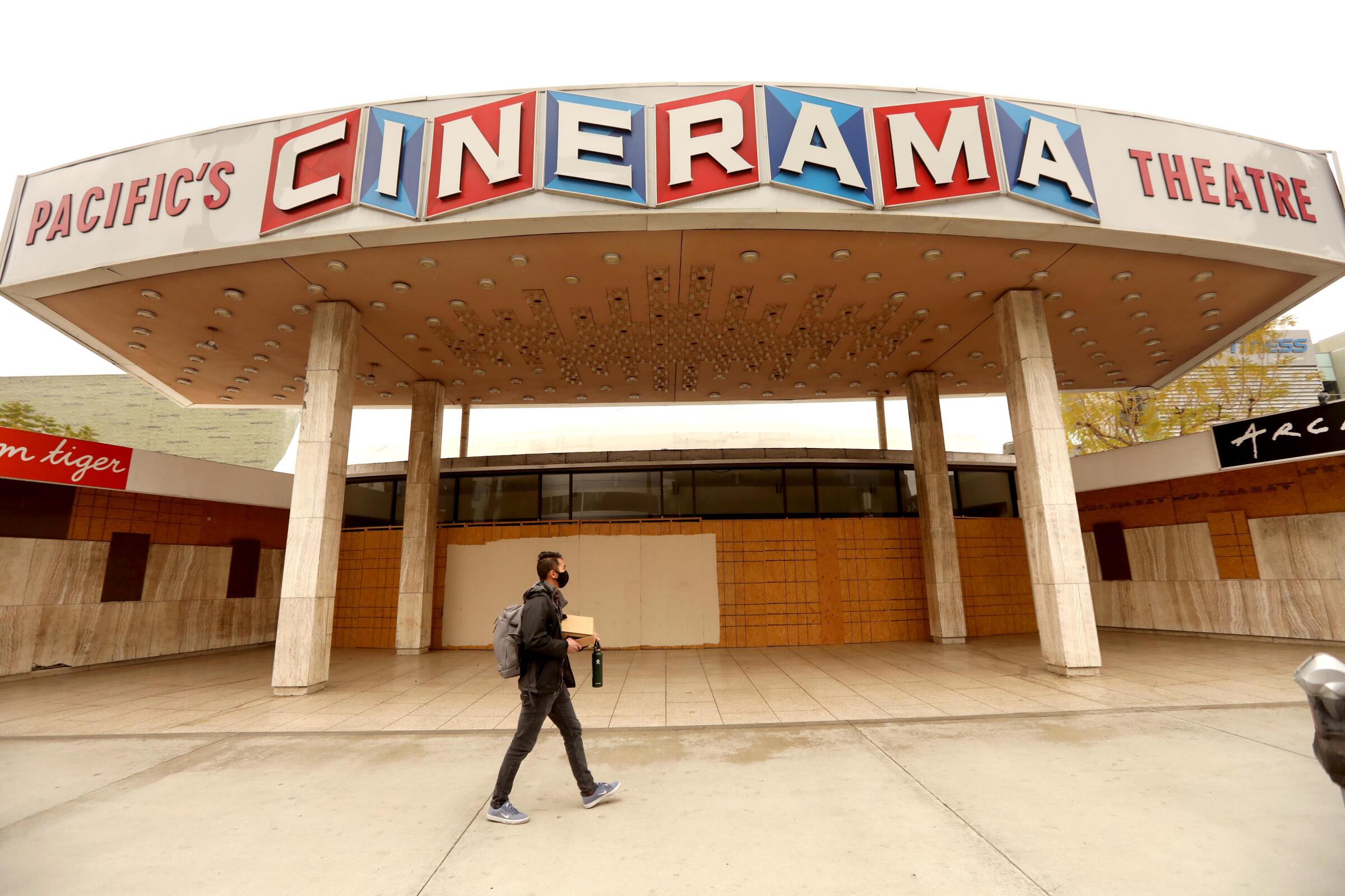 A passerby at the closed entrance to the Cinerama Dome in Hollywood. 