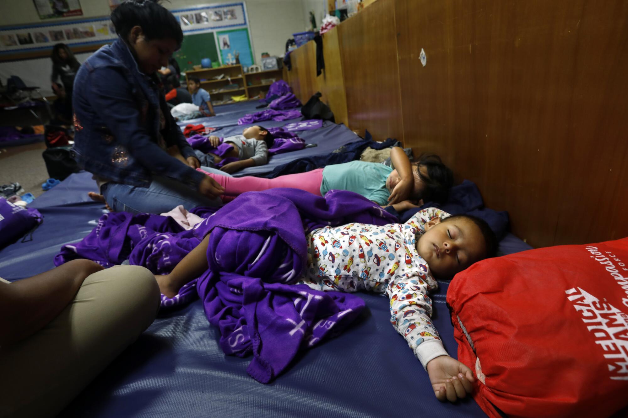 Children sleep on mats.