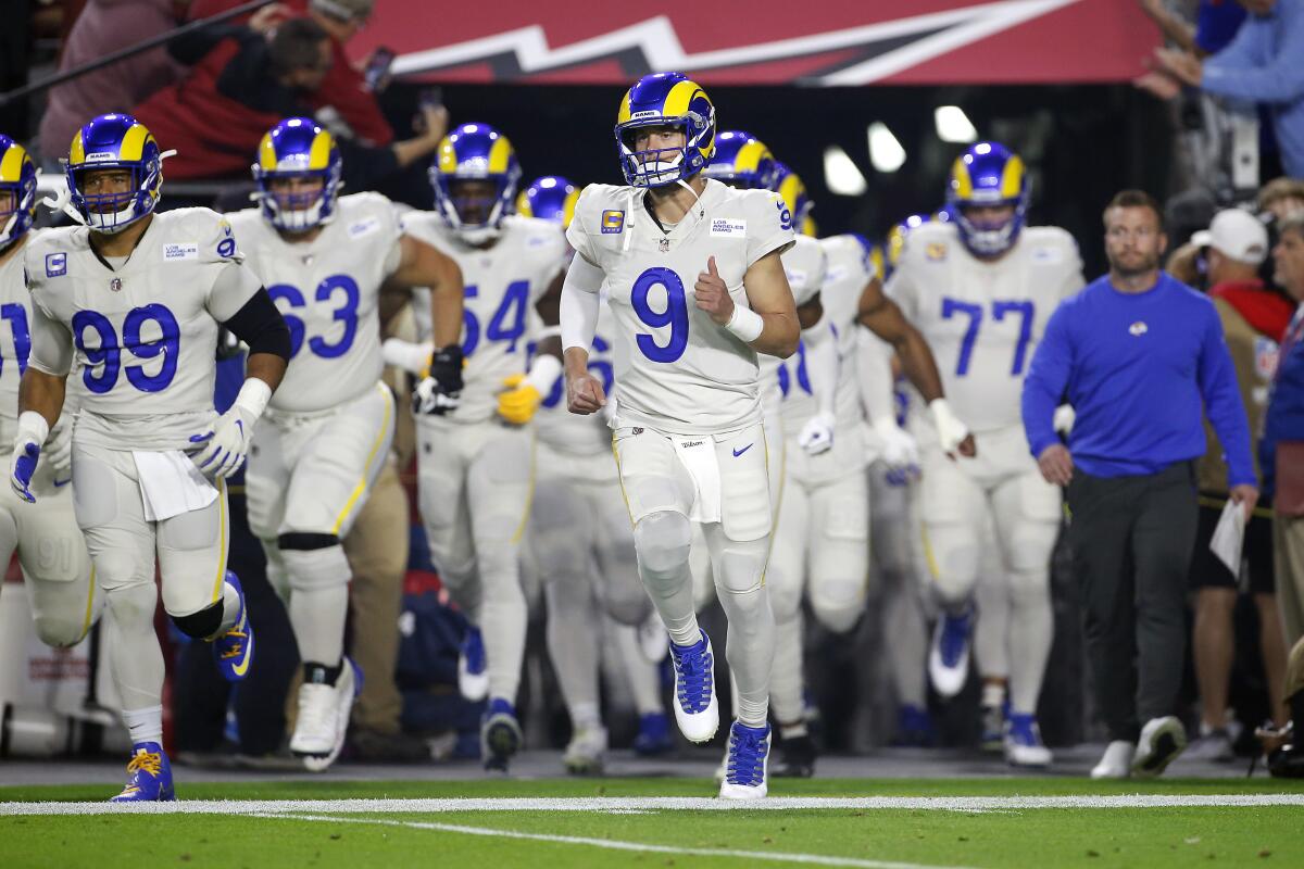 Los Angeles Rams quarterback Matthew Stafford (9) leads the team onto the field.