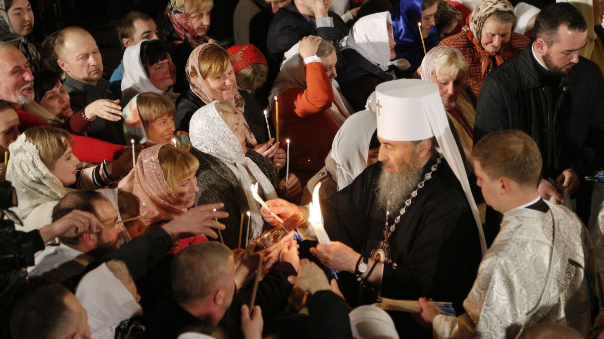 The head of the Ukrainian Orthodox Church under the Moscow Patriarchate, Metropolitan Onufri, lights believers' candles during the Easter service April 7 in the Monastery of Caves in Kiev, Ukraine.