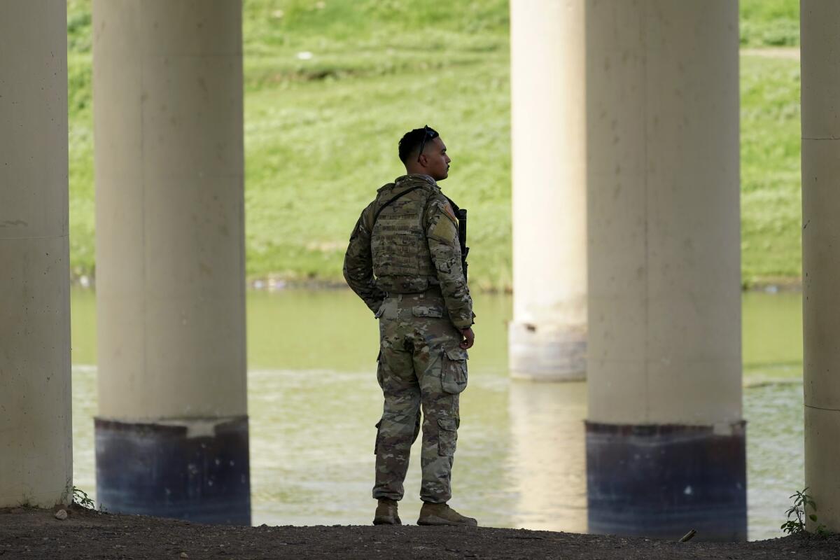 A member of the Texas National Guard looks across the Rio Grande.