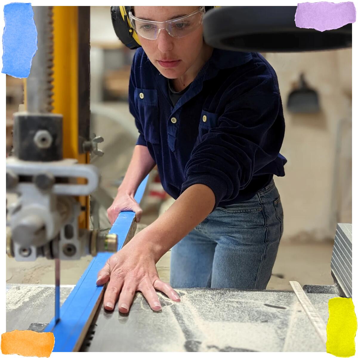 A woman in safety glasses cuts wood for a bow.