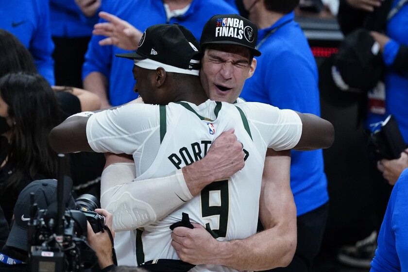 Milwaukee Bucks' Brook Lopez, right, hugs Bobby Portis after defeating the Atlanta Hawks in Game 6 of the Eastern Conference finals in the NBA basketball playoffs and advancing to the NBA Championship, Saturday, July 3, 2021, in Atlanta. (AP Photo/John Bazemore)