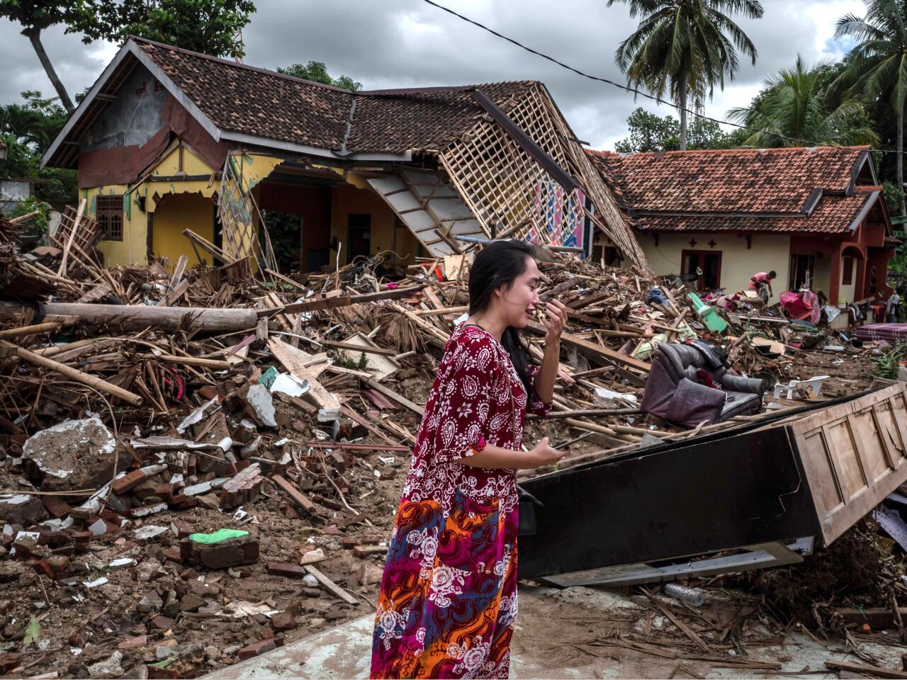 A distraught woman looks for her belongings at a house destroyed by the tsunami in Indonesia.