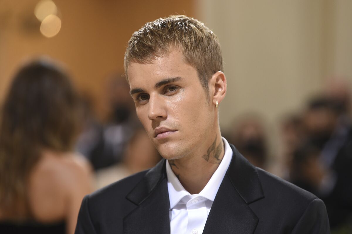 Justin Bieber in a suit tilting his head to the right