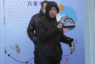 Una persona se quita la mascarilla para una prueba de COVID-19 en Beijing, el miércoles 7 de diciembre de 2022. En un brusco cambio de rumbo, China anunció varias medidas para retirar algunas de las restricciones más duras contra el COVID-19. (AP Foto/Ng Han Guan)