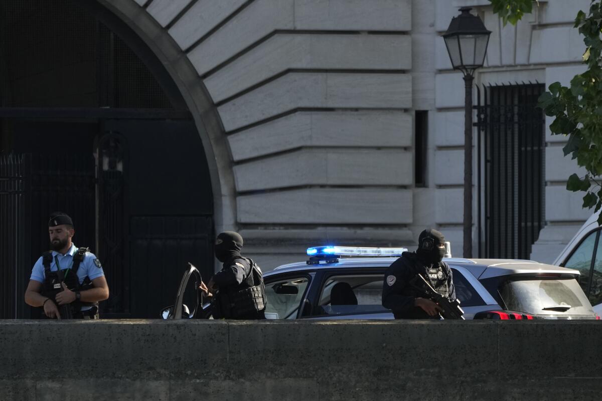 Security forces guard an entrance of a Paris courthouse.