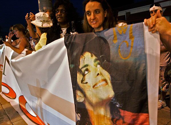 Lisadawn Marble, right, and other fans hold a banner of Michael Jackson as they wait for the pop singer's funeral service at Forest Lawn Memorial-Park in Glendale. Jackson died June 25 in Los Angeles.