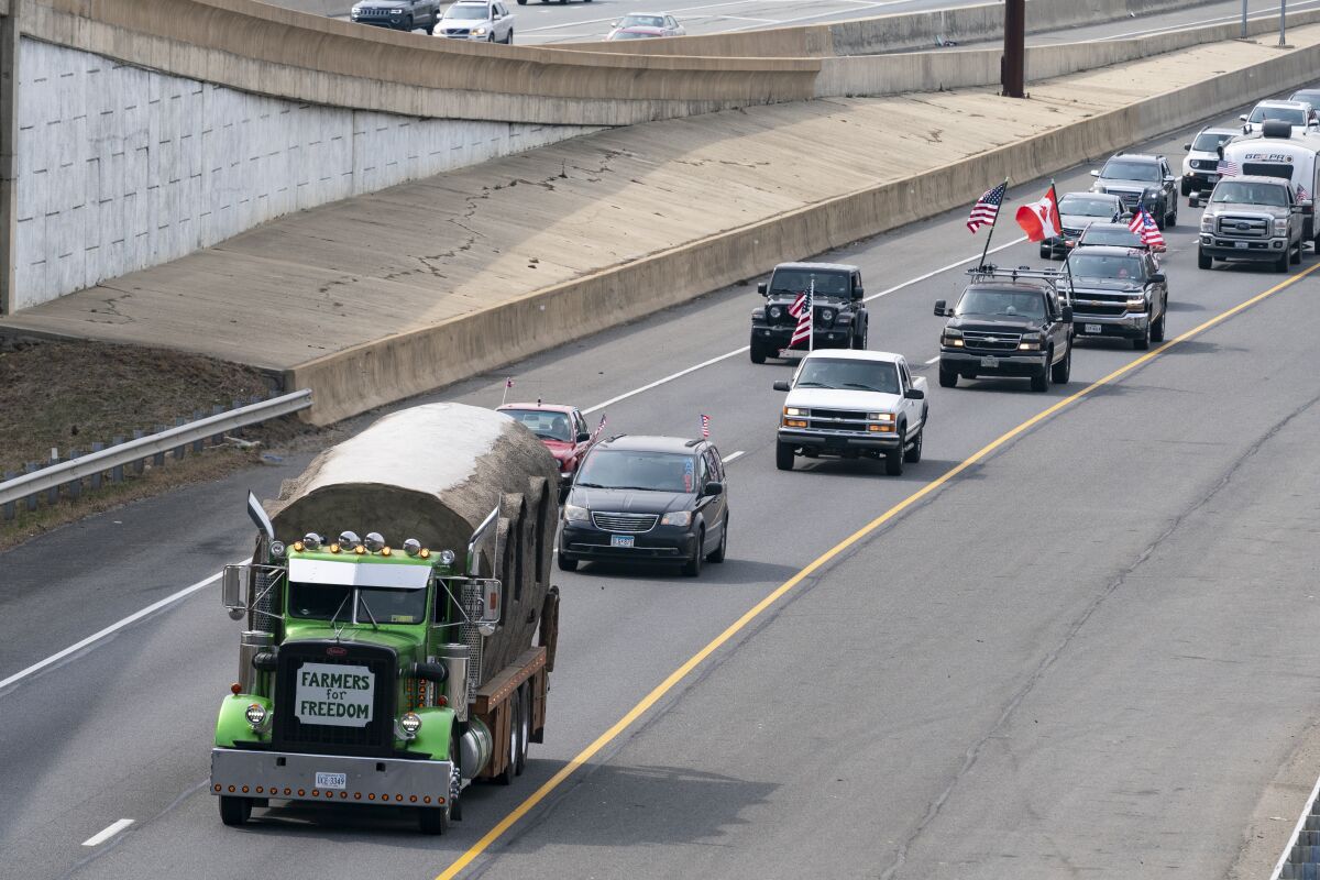 A convoy of trucks and other vehicles travels the I-495 Capital Beltway near the Woodrow Wilson Bridge, to protest mandates and other issues, Sunday, March, 6, 2022, in Fort Washington, Md. (AP Photo/Alex Brandon)