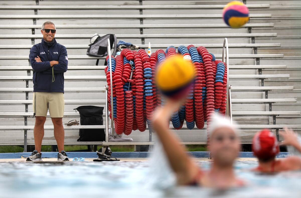 U.S. women's Olympic water polo coach Adam Krikorian watches his players from beside the pool.