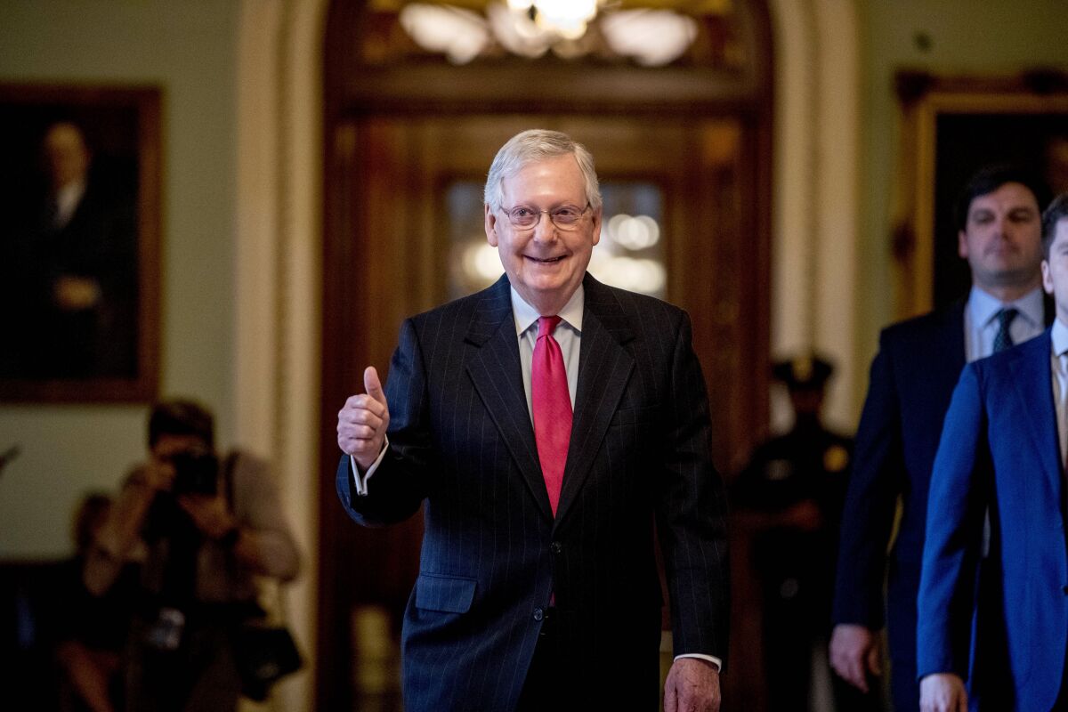 Senate Majority Leader Mitch McConnell of Ky. gives a thumbs up as he leaves the Senate chamber on Capitol Hill in Washington, Wednesday, March 25, 2020, where a deal has been reached on a coronavirus bill. The 2 trillion dollar stimulus bill is expected to be voted on in the Senate Wednesday. (AP Photo/Andrew Harnik)