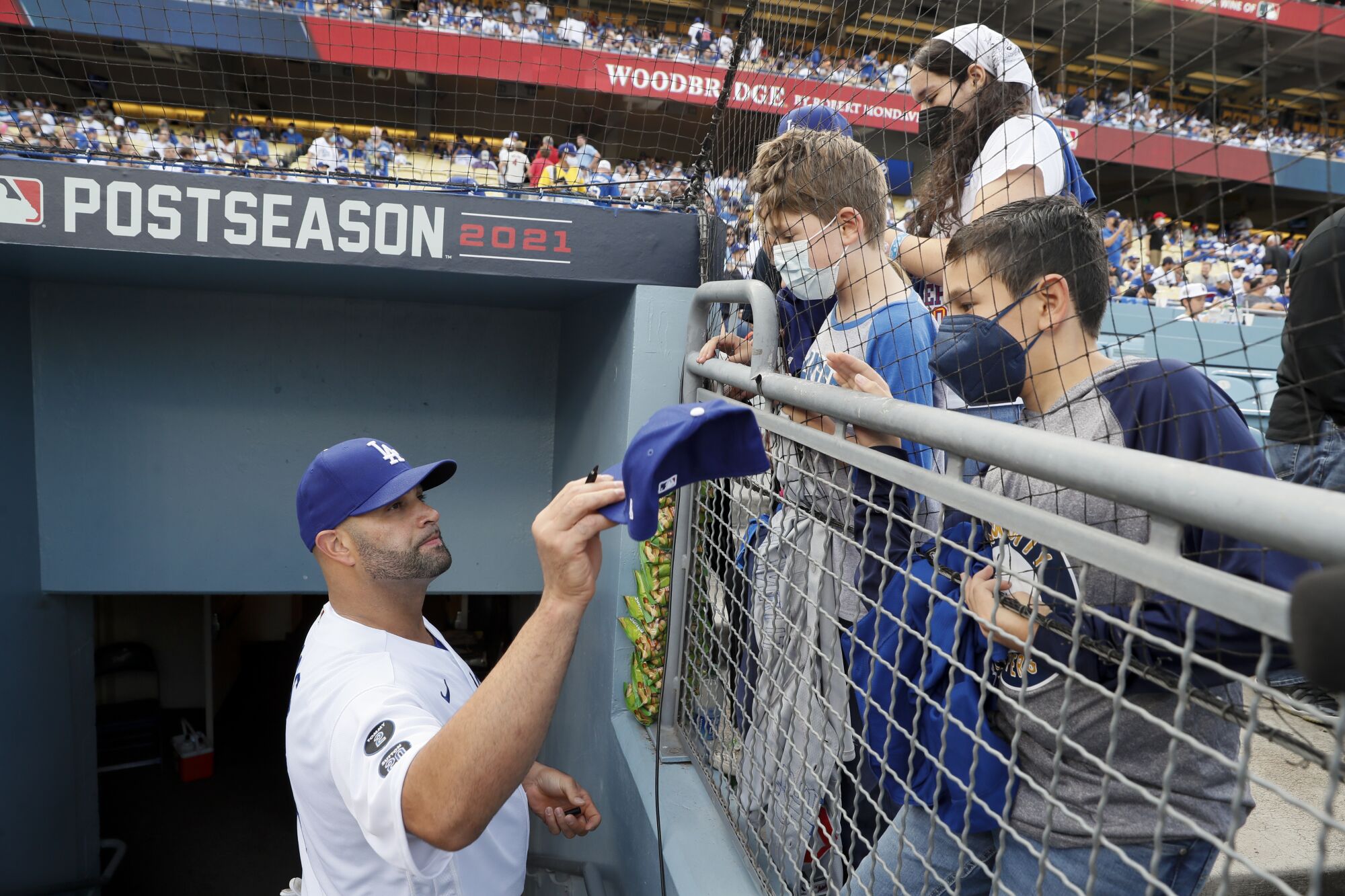Los Angeles Dodgers' Albert Pujols signs autographs for fans before the game against the St. Louis Cardinals