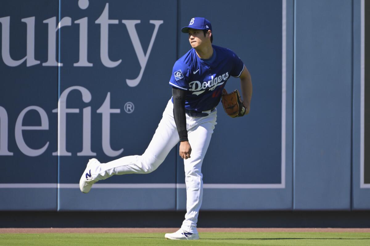 The Dodgers' Shohei Ohtani warms up in the outfield before a game against the Athletics last week at Dodger Stadium.