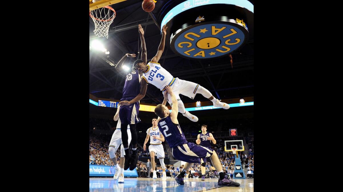 UCLA's Aaron Holiday is called for charging as he drives to the basket on Washington's Dan Kingma at Pauley Pavilion.