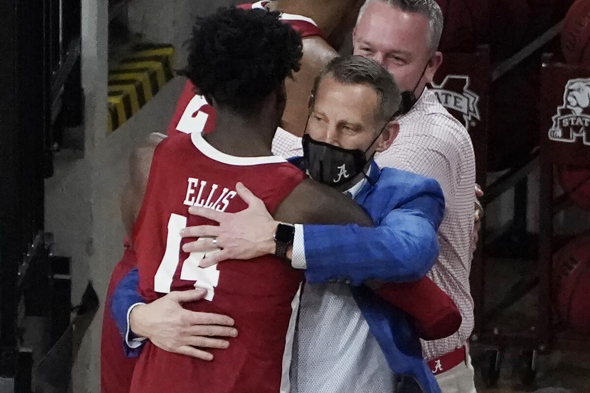 Alabama head coach Nate Oates hugs guard Keon Ellis (14) after beating Mississippi State 64-59 at an NCAA college basketball game in Starkville, Miss., Saturday, Feb. 27, 2021. With the win, Alabama captures the SEC regular season title. (AP Photo/Rogelio V. Solis)