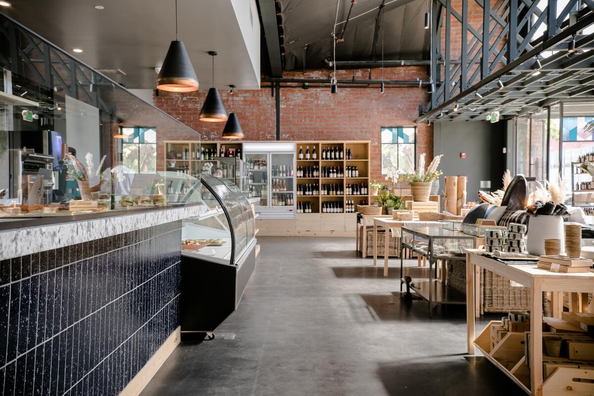 The interior of a food store with a brick wall and bottles of wine and gift items on display