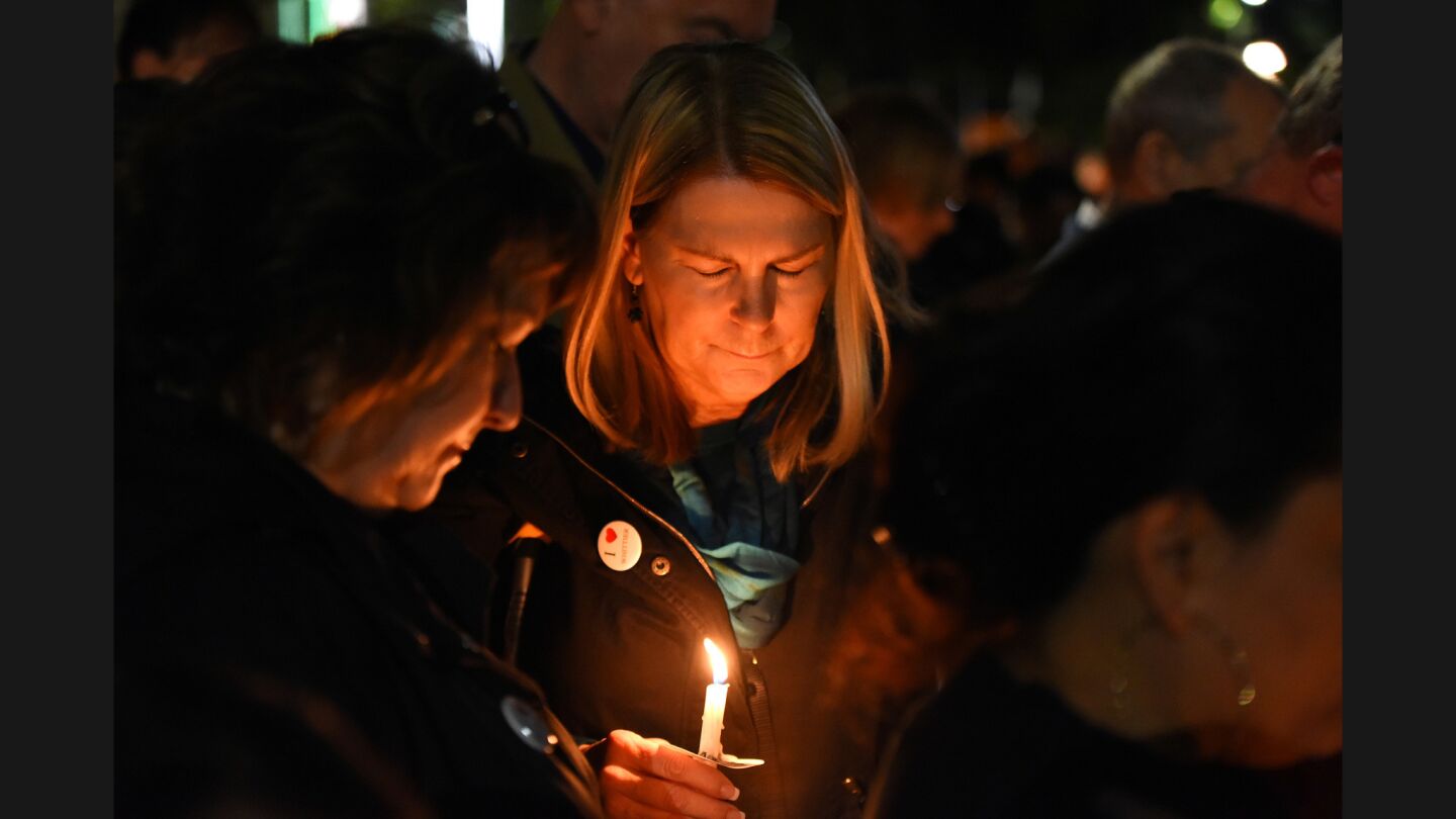 Kim Williams, center, bows her head during a prayer at a vigil for slain Whittier police officer Keith Boyer.