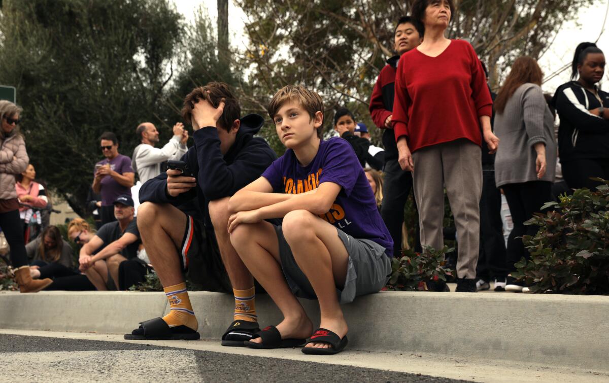 Fans gather at the corner of Las Virgenes Road and Willow Glen Street in Calabasas near the site of the crash where Kobe Bryant and his daughter Gianna were among 9 dead in a helicopter crash on Sunday.