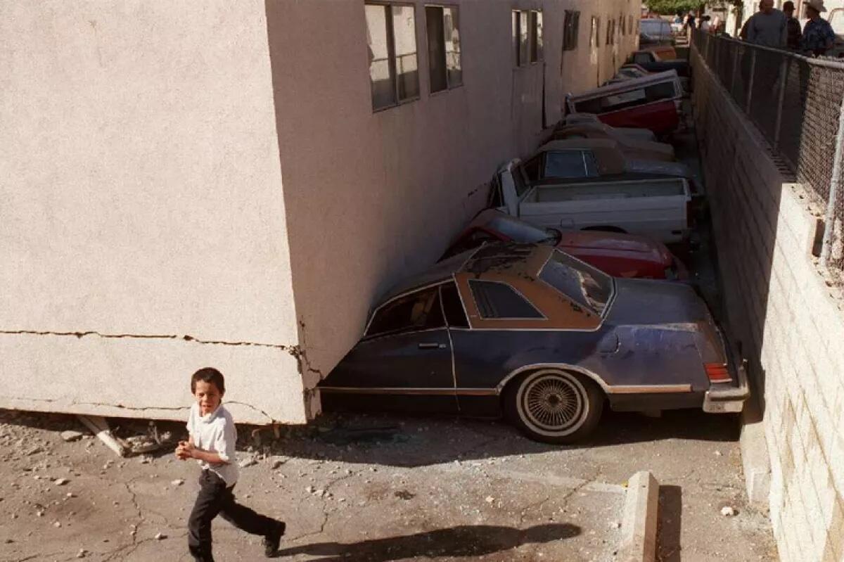 Crushed vehicles at a soft-story apartment building that collapsed during the Northridge earthquake in 1994.