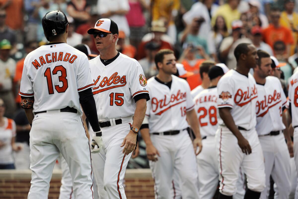 Baltimore Orioles batting coach Jim Presley, keeps Manny Machado, away from the Oakland Athletics after the benches cleared in the eighth inning Sunday.