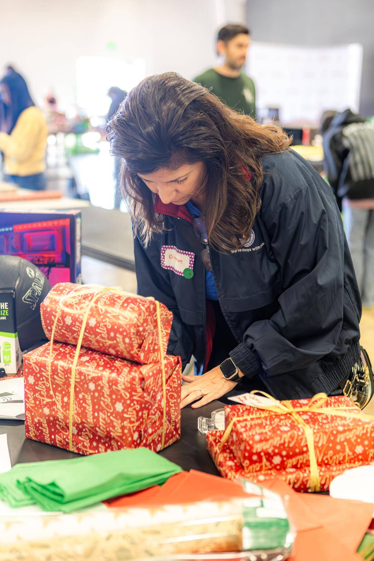 A volunteer helps wrap presents for one of 350 families that were 'unadopted.'