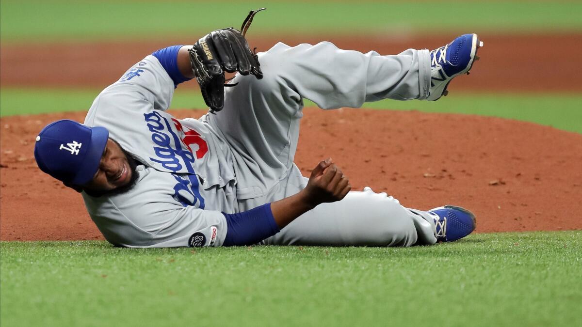 Los Angeles Dodgers reliever Pedro Baez reacts after he was hit by a line drive in the seventh inning May 21. X-rays on his right knee were negative, and Baez, walking with a limp after the game, said the knee felt significantly better.