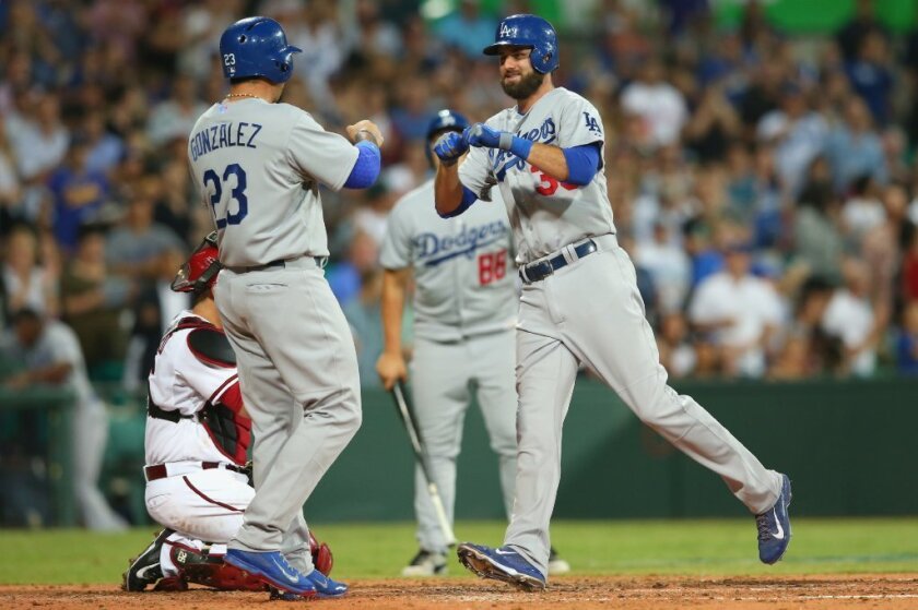 Scott Van Slyke is greeted at home plate by Adrian Gonzalez after his two-run home run.