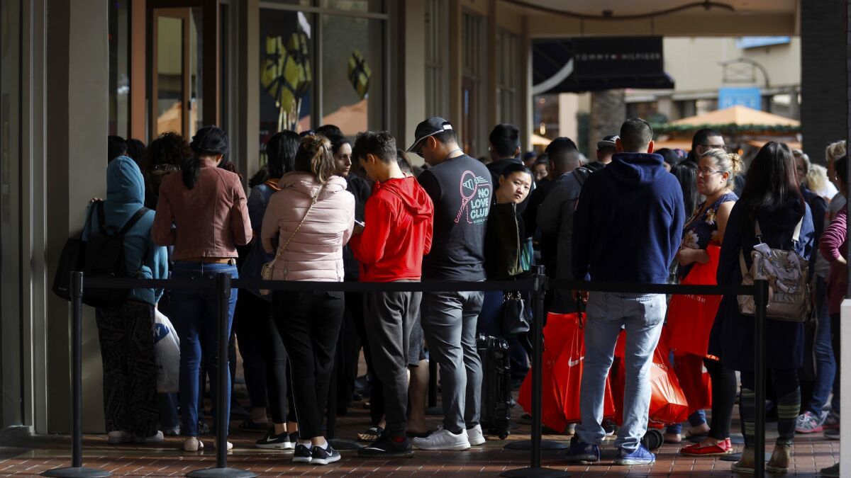 A long line formed outside the Coach store during Black Friday shopping at the Citadel in Commerce.