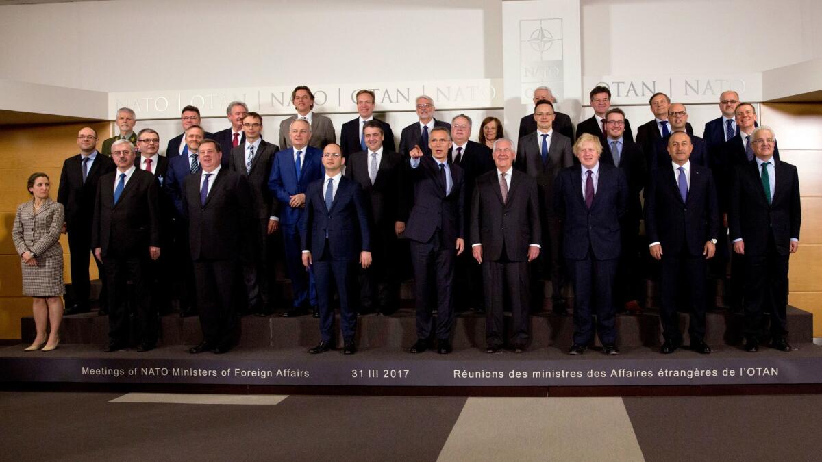 NATO Secretary General Jens Stoltenberg, center, points while standing next to U.S. Secretary of State Rex Tillerson during a group photo of NATO foreign ministers at NATO headquarters in Brussels on March 31.