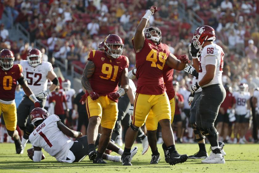 LOS ANGELES, CA - OCTOBER 8, 2022: USC Trojans defensive lineman Tuli Tuipulotu (49) and USC Trojans defensive lineman Brandon Pili (91)react after sacking Washington State Cougars quarterback Cameron Ward (1) in the first half at the Coliseum on October 8, 2022 in Los Angeles, California.(Gina Ferazzi / Los Angeles Times)