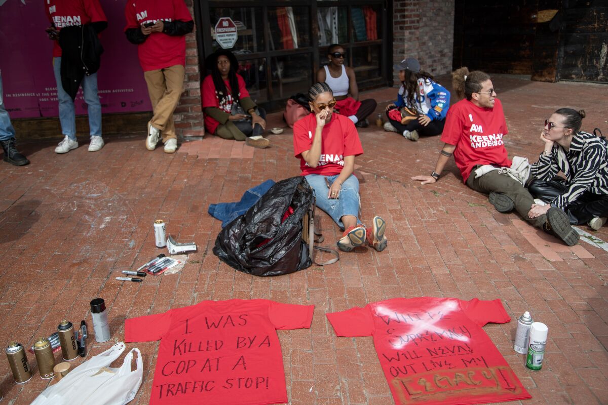 Protesters gather before their march to Frieze to write on the back of shirts.