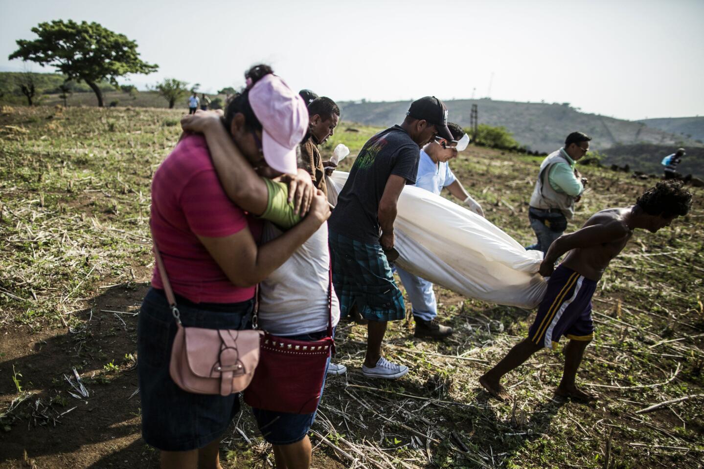 Relatives retrieve the body of Alberto Hernández near Caserío el Chumpe, El Salvador. Police believe that the 42-year-old driver was killed by gang members.