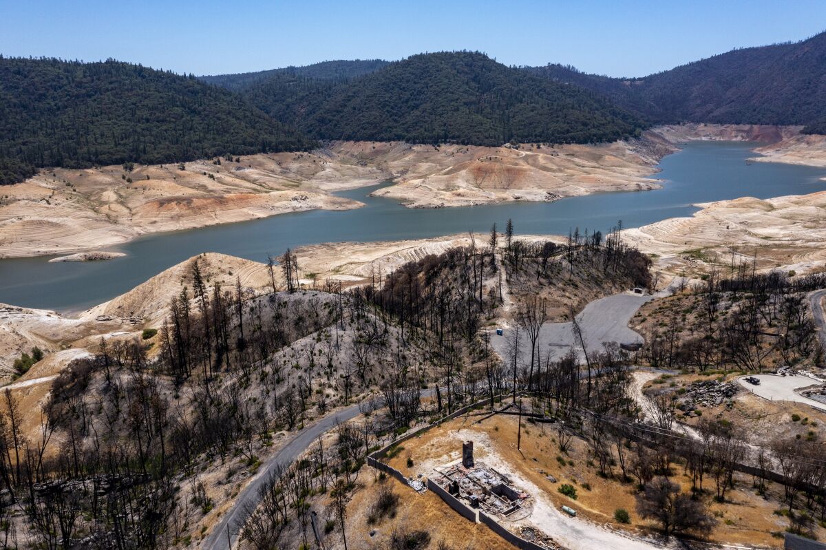 A summer 2021 view over a home burned in the North Complex fire in 2020, toward a boat ramp on Lake Oroville. 