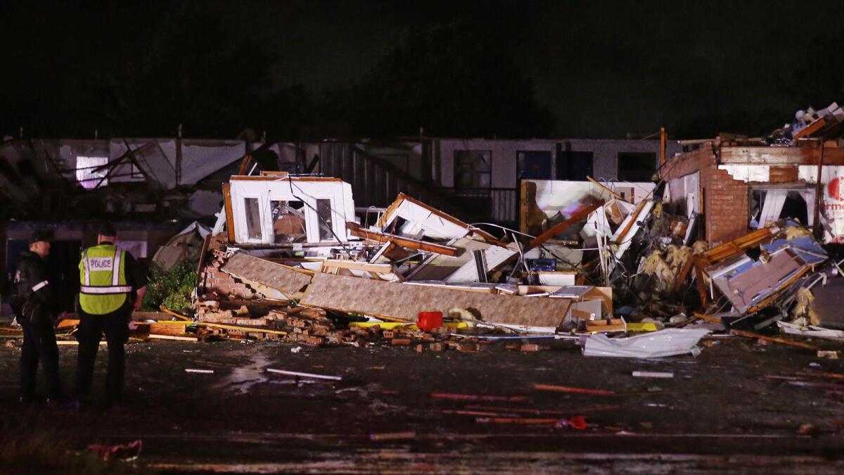 Police check the ruins of a motel in El Reno, Okla., early Sunday after a tornado touched down the night before.