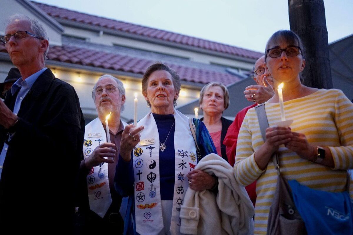 Mourners attend a candlelight vigil at the Rancho Bernardo Community Presbyterian Church on Saturday night in Poway.