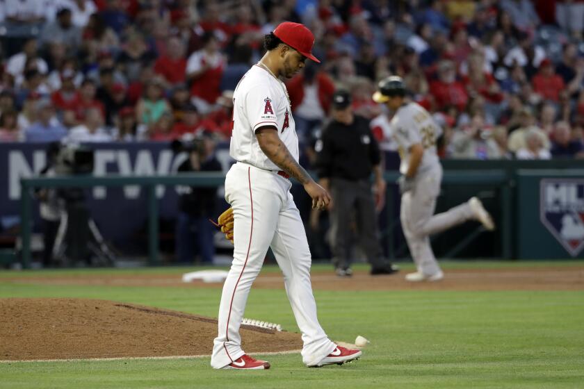 Los Angeles Angels relief pitcher Felix Pena walks off the mound after giving up a three-run home run to Oakland Athletics' Matt Olson, background right, during the third inning of a baseball game Friday, June 28, 2019, in Anaheim, Calif. (AP Photo/Marcio Jose Sanchez)