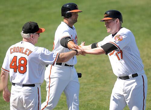 Orioles first baseman Aubrey Huff (right) is congratulated by third baseman Scott Moore (center) and hitting coach Terry Crowley after scoring against the Florida Marlins.
