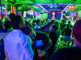 People partying in a club, illuminated in green and purple hues